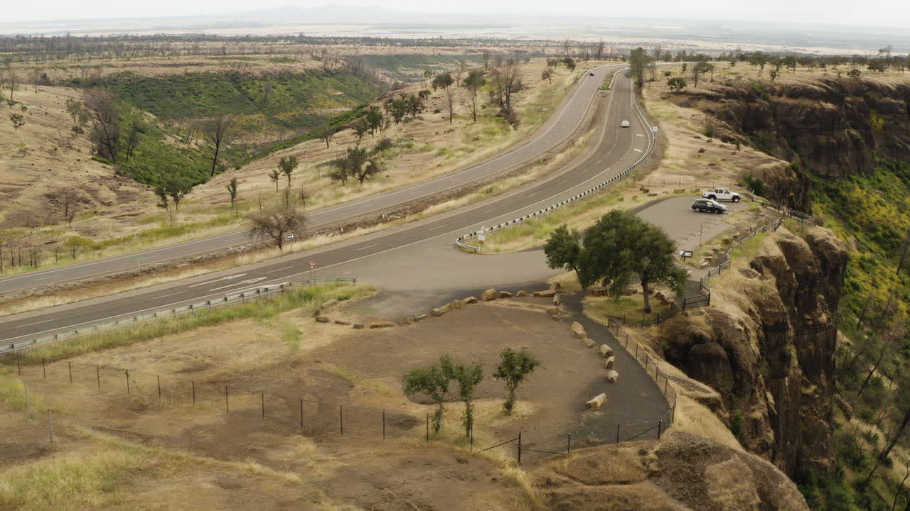 Burned trees stand next to road near Butte Creek lookout, old forest fire, natural canyon in national park in America, aerial, flying low
