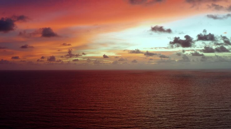 Aerial drone shot of a stunning golden pink and orange sunrise with the vast ocean below on a warm summer morning in Northern Brazil near Joao Pessoa