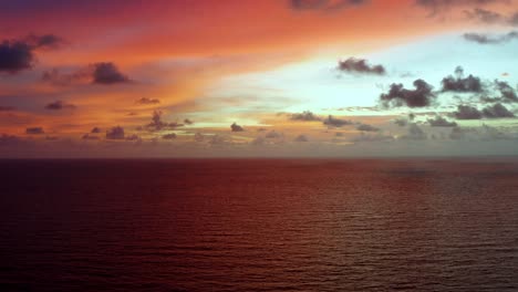 Toma-Aérea-De-Un-Impresionante-Amanecer-Dorado-Rosa-Y-Naranja-Con-El-Vasto-Océano-Debajo-En-Una-Cálida-Mañana-De-Verano-En-El-Norte-De-Brasil-Cerca-De-Joao-Pessoa