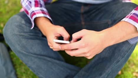 Estudiante-Sentado-Afuera-Enviando-Mensajes-De-Texto-Por-Teléfono