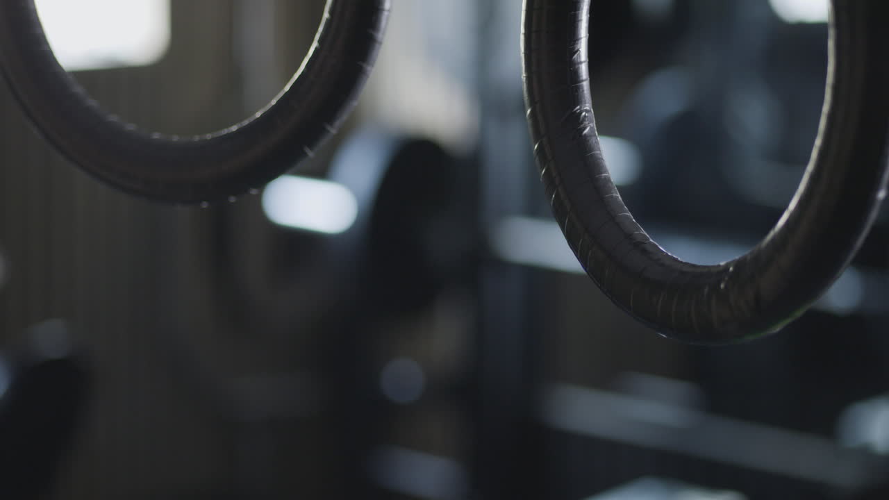 Static view of rings in motion, gymnasium in the background
