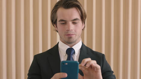 close-up-portrait-of-attractive-young-successful-businessman-checking-messages-using-smartphone-professional-male-entrepreneur-texting-browsing-working-mobile