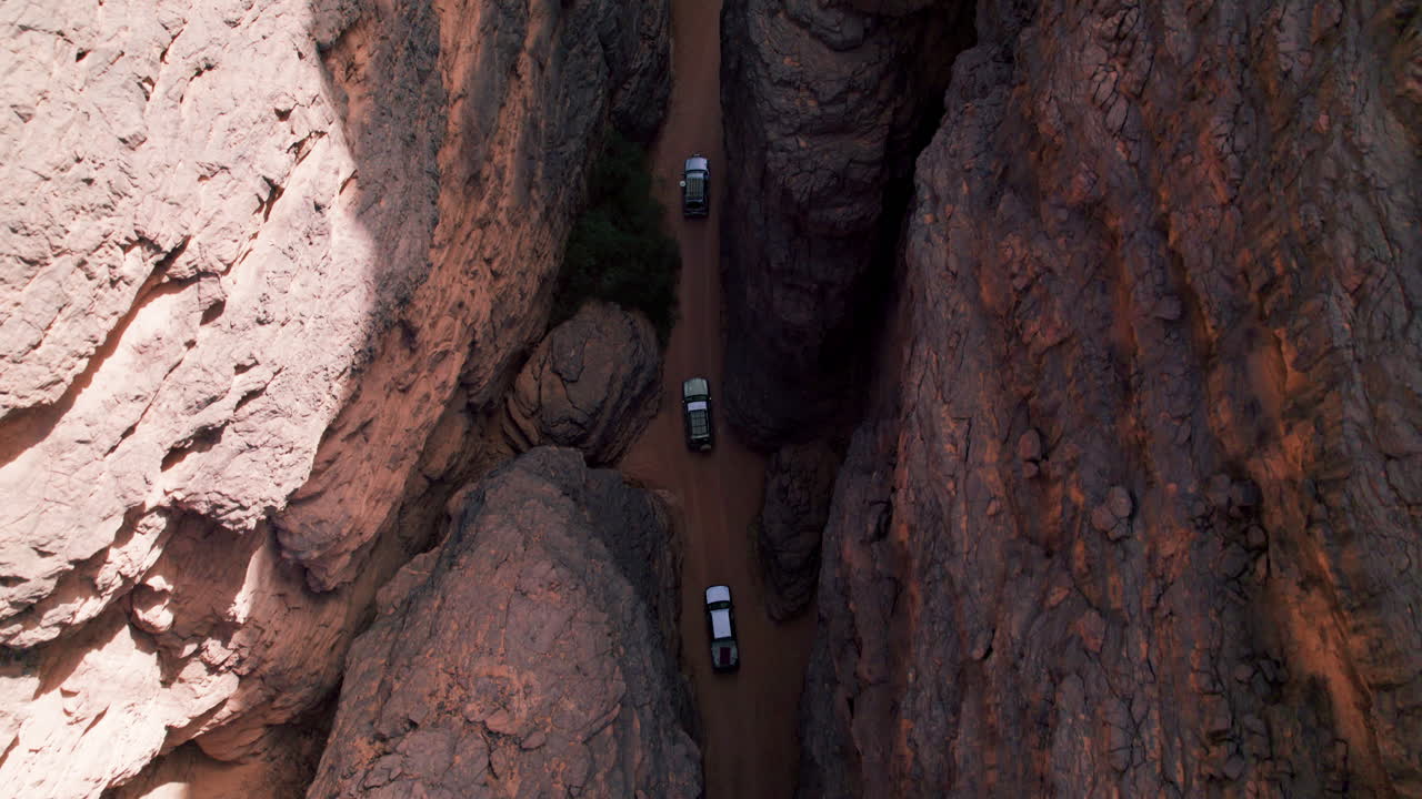 Top View Of Cars Driving Amidst Vast Plateau In Tassili N'Ajjer National Park In Southeastern Algeria