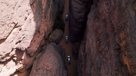 top view of cars driving amidst vast plateau in tassili n'ajjer national park in southeastern algeria