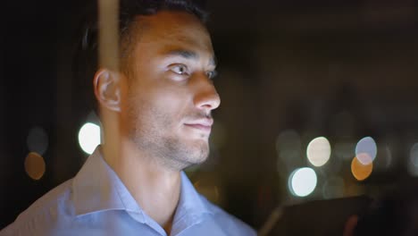 hombre de negocios biracial pensativo mirando hacia otro lado, trabajando hasta tarde en la oficina por la noche, en cámara lenta