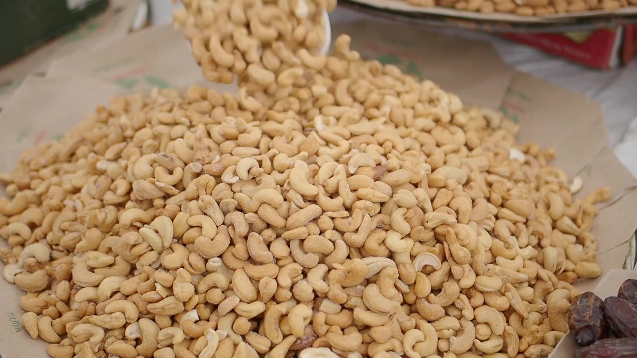 Scooping Roasted Cashew Nuts from a Large Pile