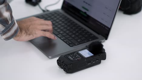 Professioneller-Redakteur-Synchronisiert-Audiorecorder-Mit-Laptop