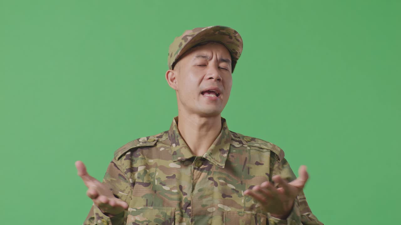 Close Up Of Wondering Asian Man Soldier Saying Why And Standing Doubtfully In The Green Screen Background Studio