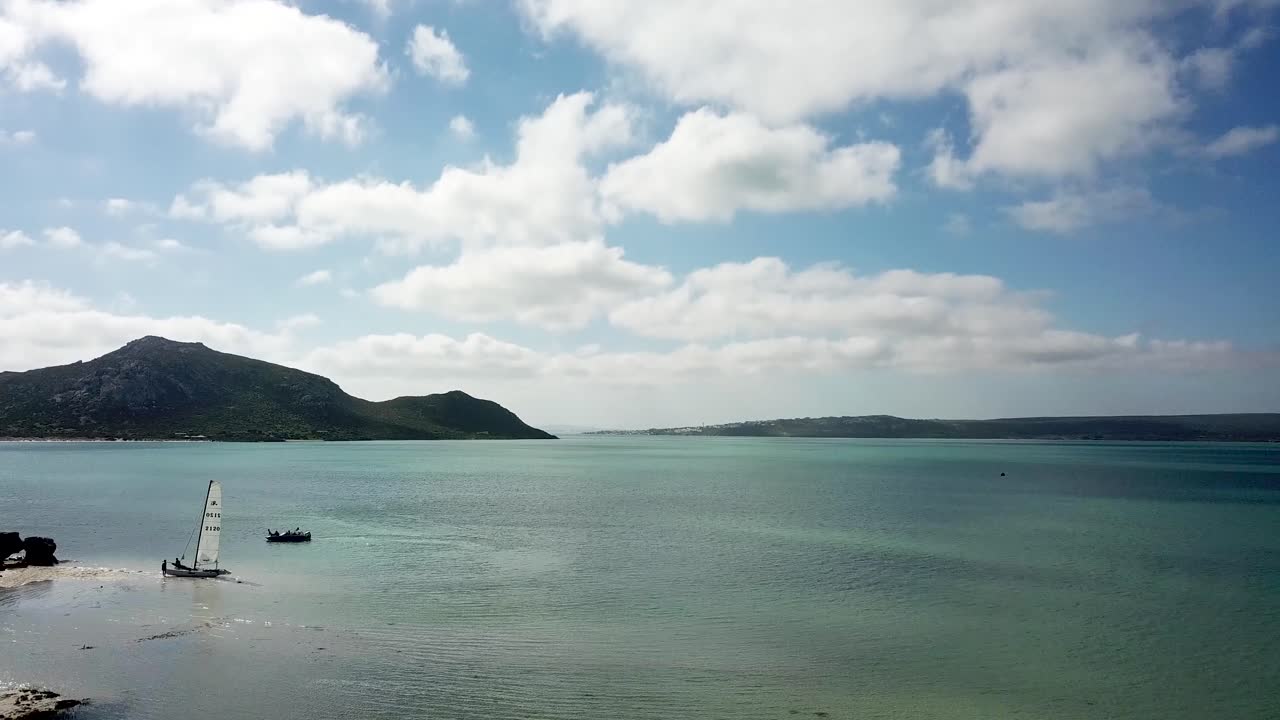 바다 위로 요트 가까이 날아가는 드론 샷
