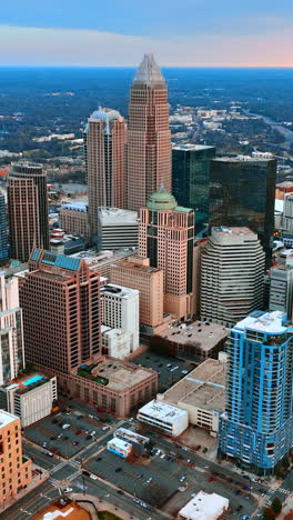 flying closer to the high-rise architecture in the uptown of charlotte, nc, us. vast scenery with lots of greenery at backdrop. vertical video