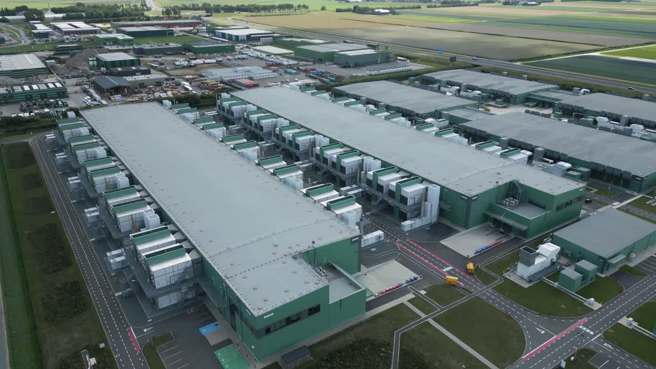 drone aerial shot of a large modern data center complex surrounded by fields and infrastructure in the Netherlands - Eemshaven