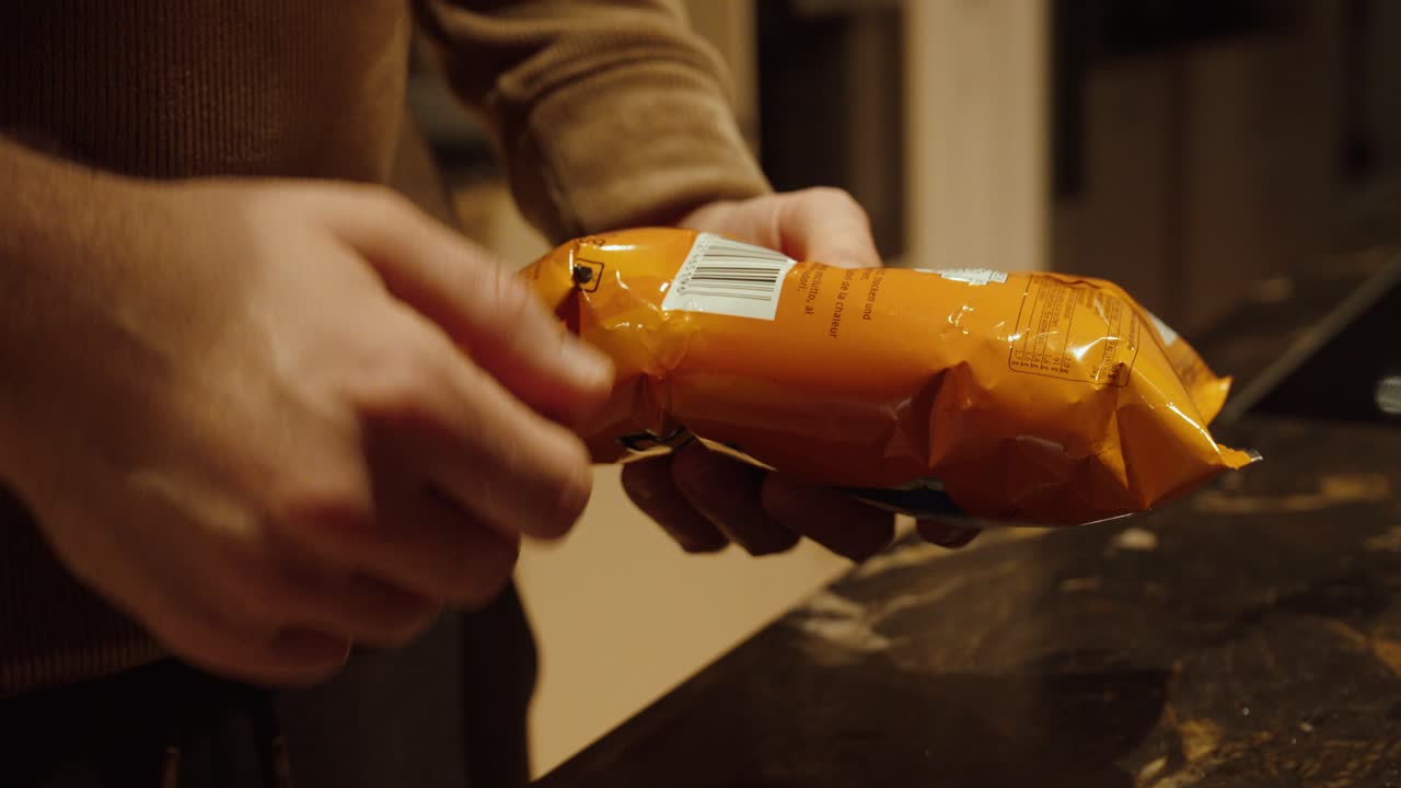 Close-up of a person checking allergen information and calorie values on a packaged food product in the kitchen. Concept of healthy eating, food safety, dietary awareness, and nutrition control