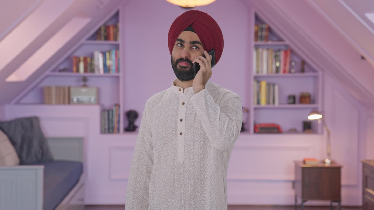 Uomo Sikh indiano felice che parla al telefono