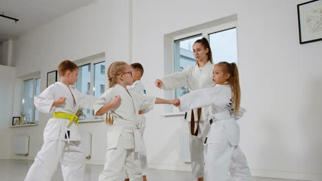 kids in white kimono and teacher in martial arts class