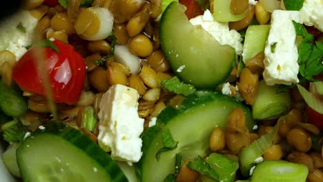 Close-up-of-oil-being-drizzled-onto-a-feta-and-lentil-salad