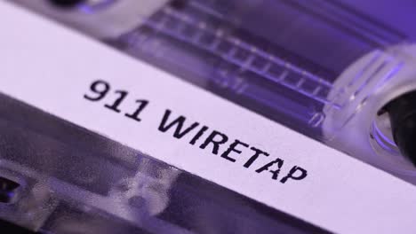 911 wiretap recording on audio cassette tape playing, macro close up detail