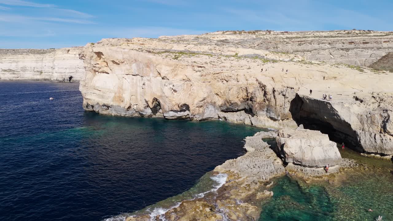 Ripresa aerea con drone delle scogliere di Dwejra a Gozo, Malta, filmato 4K cinematografico a 60 FPS che mostra la spettacolare costa calcarea e il paesaggio marino mediterraneo