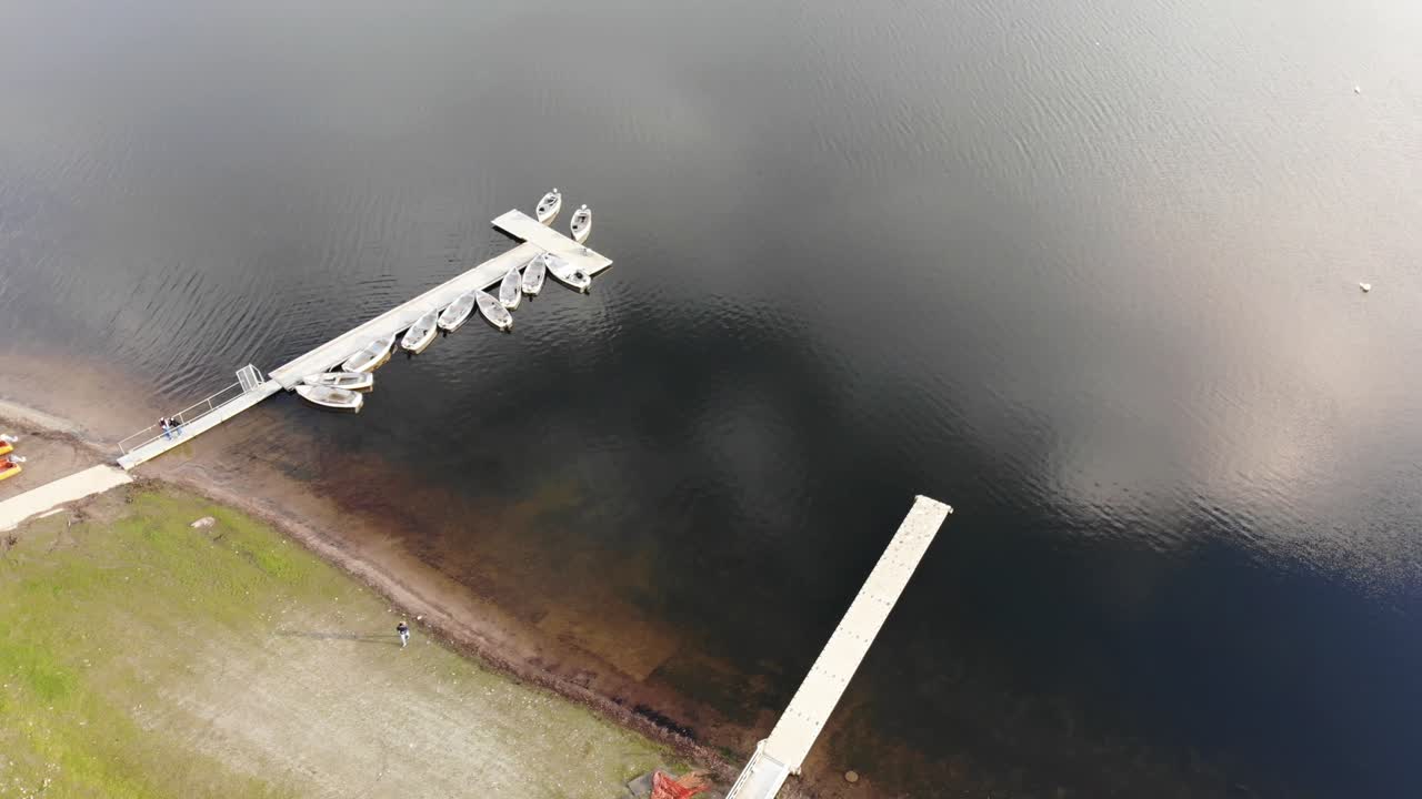 부두 옆에 빈 보트가 있는 서머셋의 엑스무어에 있는 윔블볼 호수 위의 공중