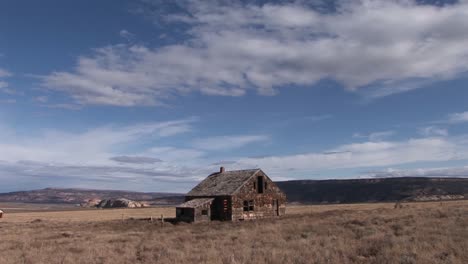 tiro largo de una vieja granja abandonada en medio de una pradera solitaria