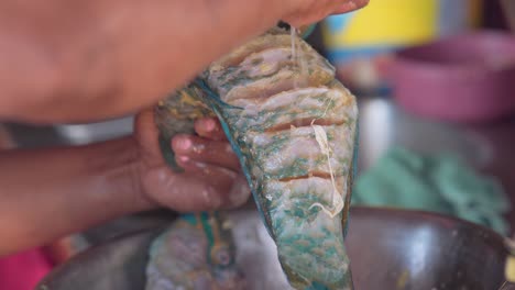 la mujer añade limón como parte de los ingredientes para sazonar un pescado, primer plano