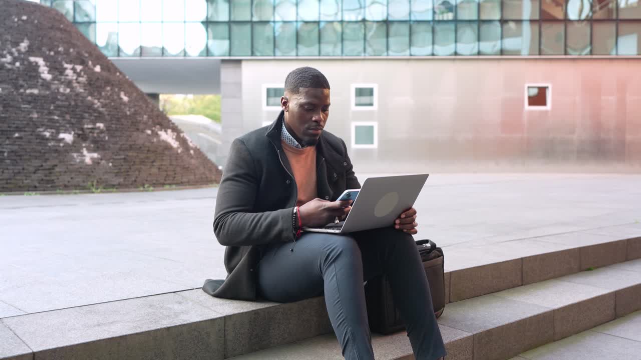 Businessman working on laptop outdoors