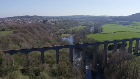 a narrow boat, canal boat crossing the pontcysyllte aqueduct, designed by thomas telford, located in the beautiful welsh countryside, famous llangollen canal route, as walkers make their way across