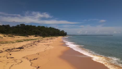 Low-aerial-drone-flight-over-an-empty-beach-in-remote-north-Queensland,-Australia