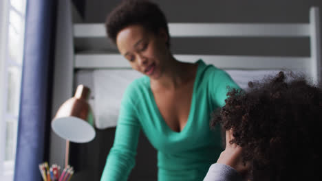 Mixed-race-mother-and-daughter-drawing-in-a-notebook