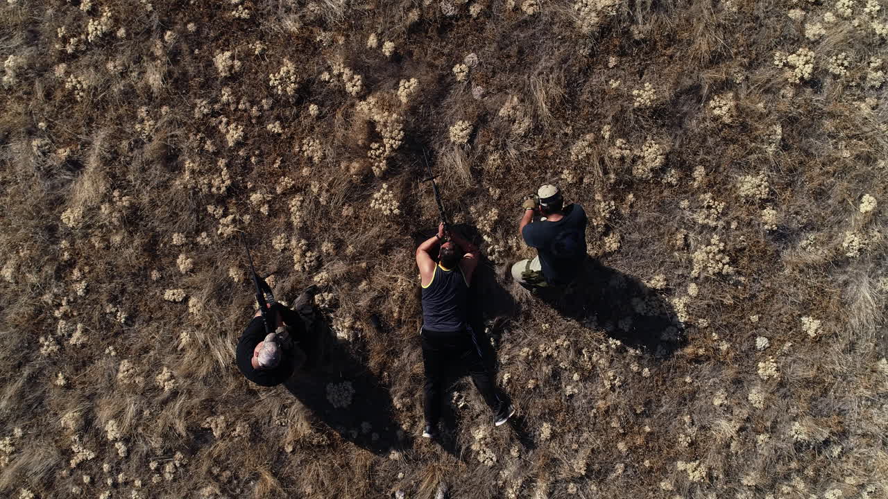 three men getting ready to shoot a target for practice with a rifle