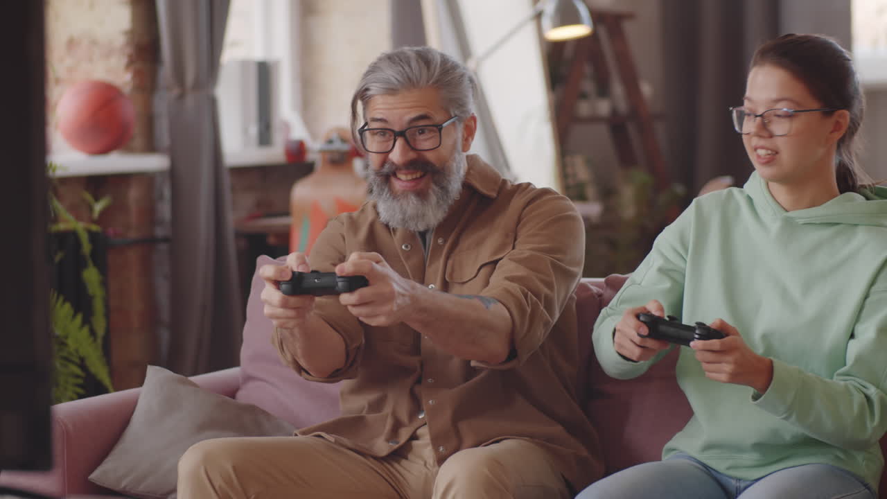 ragazza adolescente che gioca a console con il padre a casa