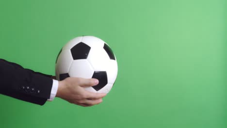 hand of businessman holding a soccer ball with green screen, video in 4k