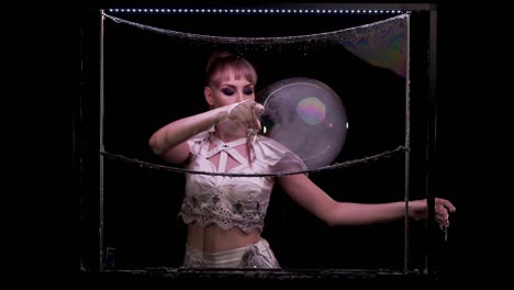 pretty girl does tricks with soap bubbles. she plays with bubbles, pierces, releases smoke. with color highlights