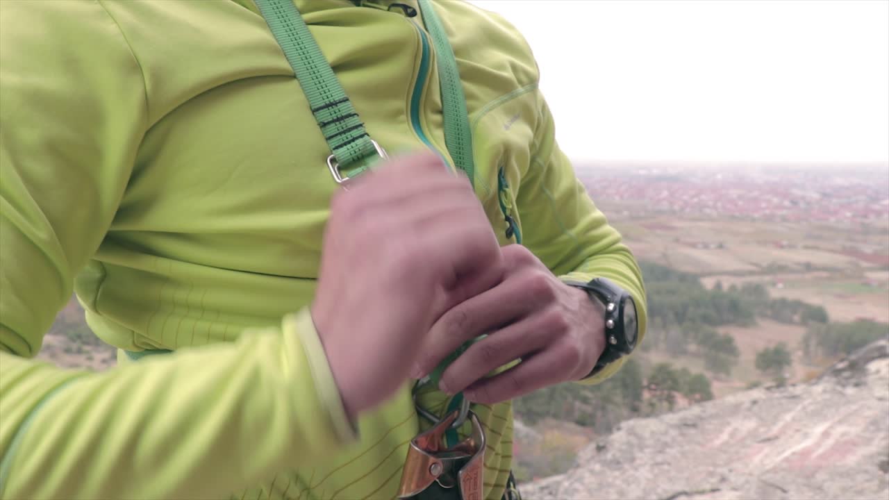 escalador asegurando un chaleco antes de escalar