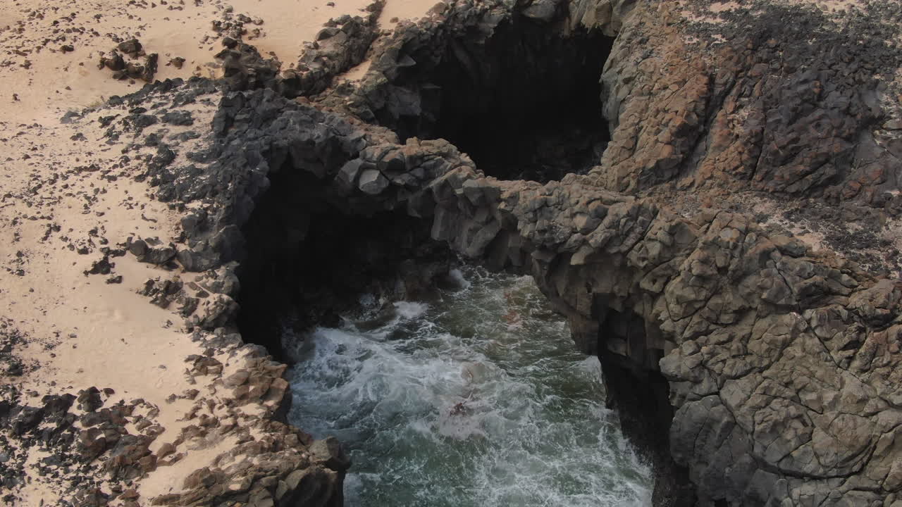 Arco di Caletones: onde dell'oceano che turbinano all'interno di una piscina naturale formata da roccia vulcanica sull'isola di La Graciosa