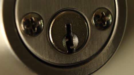 key inserted into deadbolt door lock and turned to the left and removed residential close up