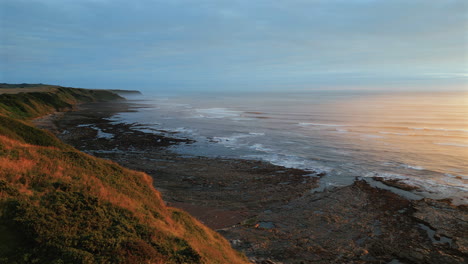 Luftdrohnenaufnahme-Von-Cleveland-Weit-Draußen-Am-Meer-Zur-Goldenen-Stunde-An-Einem-Nebligen-Morgen-Bei-Ebbe-In-Scarborough