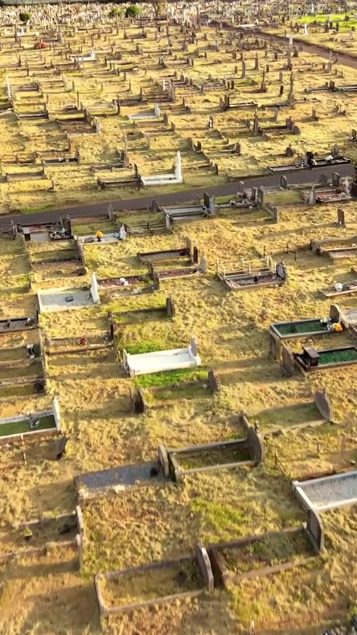 Video udara yang melintas di atas Pemakaman Milltown di Belfast Barat, Irlandia Utara pada malam musim panas yang cerah. Diproduksi dalam 60 FPS, rasio sosial 1080x1920, dan dengan warna Rec709.