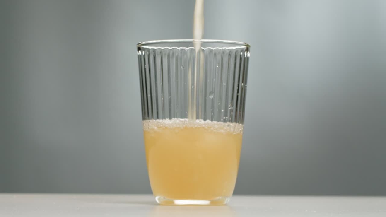 Orange or white wine bottle and glass, spanish french apple cider pouring, pouring of ecological natural wine.