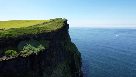 Rückwärtige-Drohnenansicht-Steile-Klippen-Von-Moher-Mit-Moosigen-Rändern-An-Sonnigen-Tagen