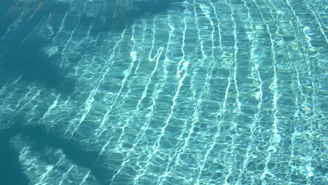 water surface texture, slow motion clean swimming pool ripples and wave, refraction of sunlight top view texture sea side white sand, sun shine water background. water caustic background.