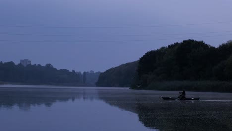 a man floats in a boat on the river at dusk. horror.