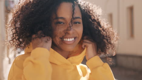 smiling woman wearing a yellow hoodie