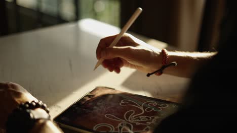 close-up of a person drawing on an ipad with an apple pencil