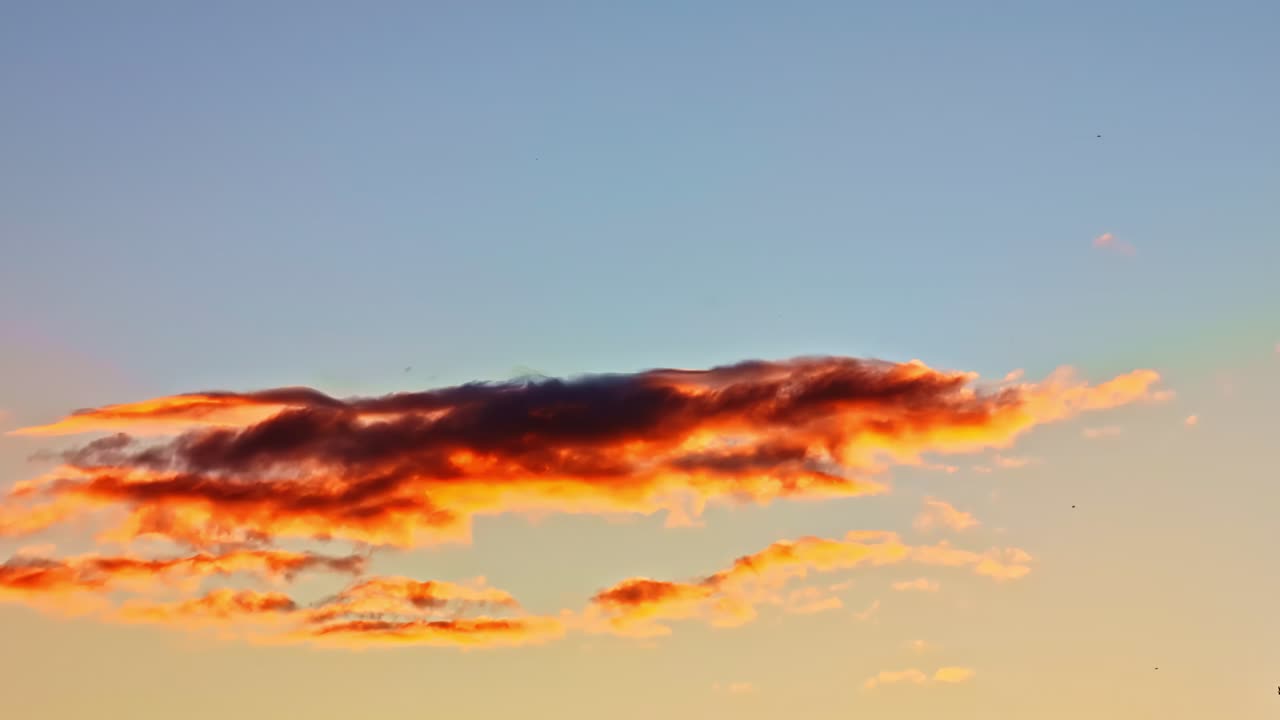 Dark red cloud formation in glowing sky during evening twilight, natural background
