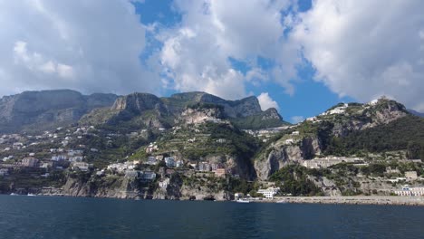 view from a boat of hotels and houses on a hillside above positano on the amalfi coast, italy - pov