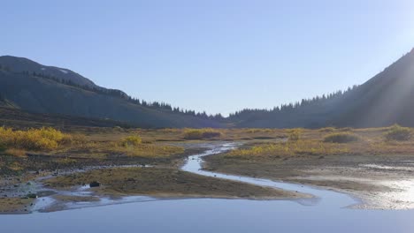 Ruhige-Aussicht-Auf-Feuchtgebiet-Und-Fluss-Mit-Bergketten-Im-Hintergrund