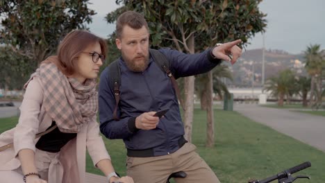 una pareja discutiendo direcciones en el parque.