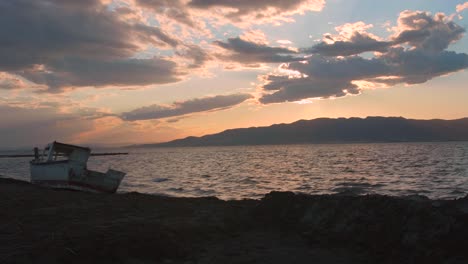 Bootswrack-Am-Strand-Mit-Malerischem-Ozean-Bei-Sonnenuntergang