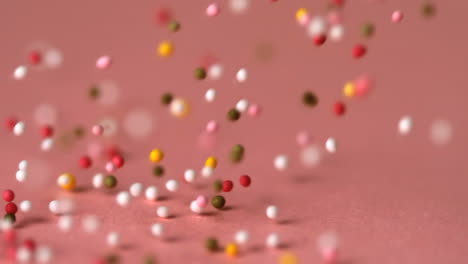 Sprinkles-falling-on-pink-surface