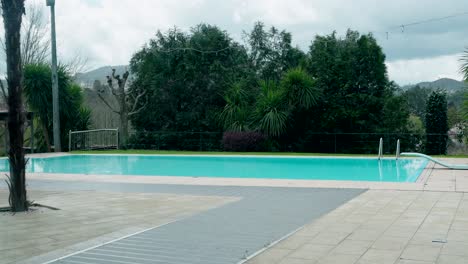 large empty pool with cloudy skies and wet tiles in calm outdoor setting